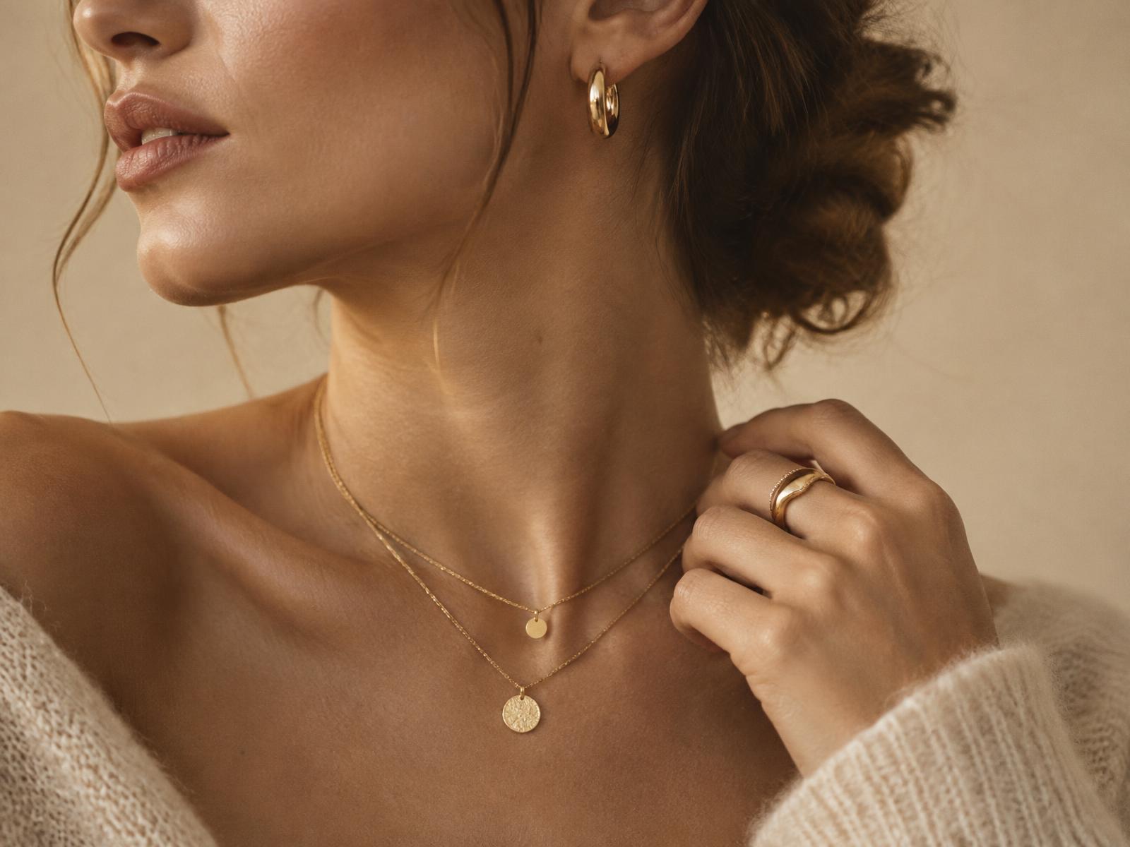 Model wearing MUOSHA gold hoop earrings, layered necklaces and stacked rings